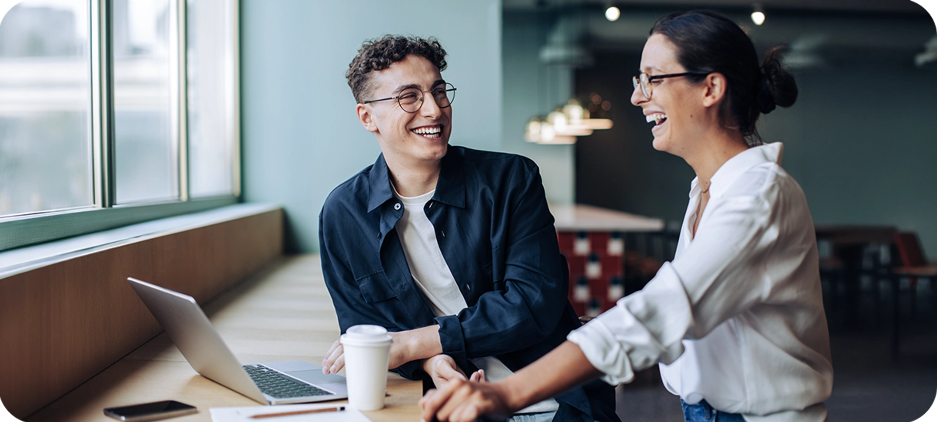 Two people laughing while investing